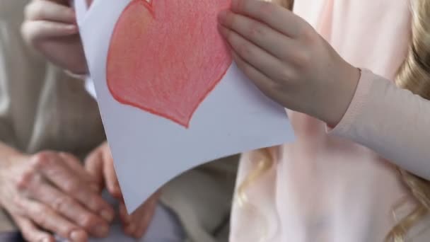 Chica mostrando abuela tarjeta de felicitación hecha a mano con el corazón, el amor de la familia, el cuidado — Vídeos de Stock