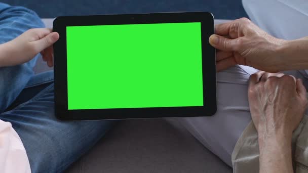 Зрелая дама и маленький ребенок руки держат планшет с зеленым экраном, технологии — стоковое видео