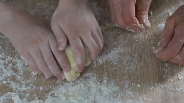 Grandma carefully and patiently teaching granddaughter kneading dough, family — Stock Video