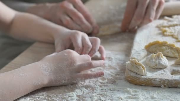 Sweet little girl trying to cook pastry, helping her granny in kitchen, family — Stock Video