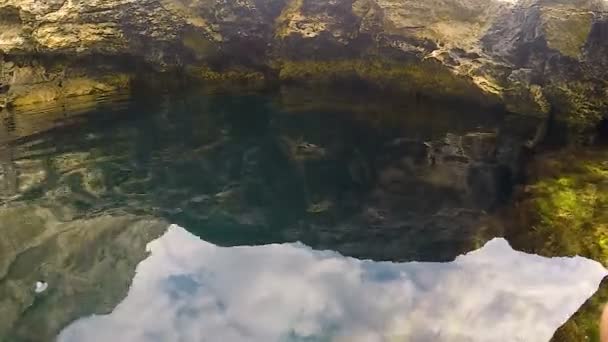 Відбиття скелі в темній воді, морська поверхня як дзеркало, красива природа — стокове відео