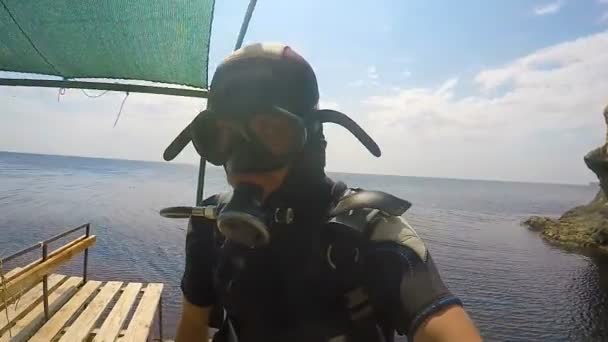 Mannen bär dykning utrustning stående på kant redo att hoppa, visar tummen upp — Stockvideo