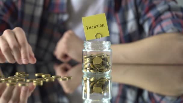 Urlaubswort über Glas mit Geld geschrieben, Ersparnisse für Sommerreise — Stockvideo