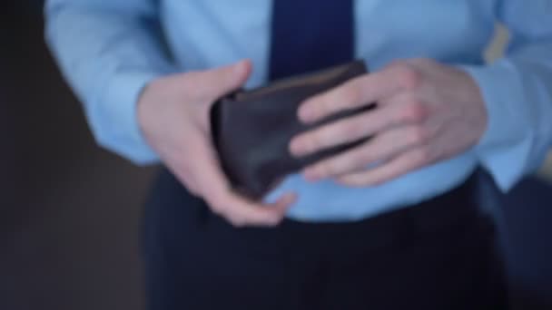 Чоловік бере монети з гаманця, даючи зміну в магазині, низький дохід, бідність — стокове відео