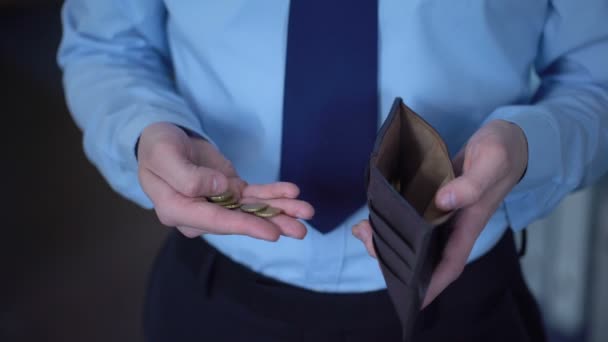 Чоловік підраховує монети, ховає їх у гаманець, низький дохід, браку грошей, бідність — стокове відео