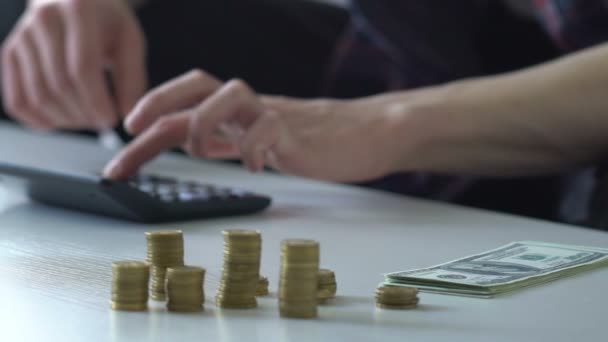 Man van de inkomens van de berekening, plaatsen van spaargelden naar de piggy bank, geld voor geschenken, reizen — Stockvideo