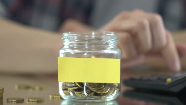 Studenten zählen Stipendien, sparen Münzen im Glas, Geld für Träume — Stockvideo