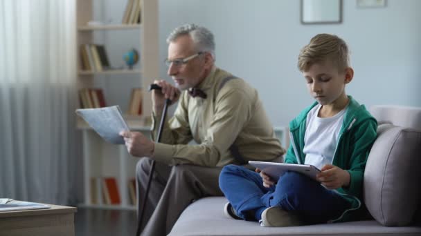 Γέρος διαβάζει τύπου, αγόρι χρησιμοποιεί tablet, σύμβολο προόδου από χαρτί σε ηλεκτρονικά — Αρχείο Βίντεο