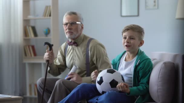 祖父と孫の損失に腹を立て、家で一緒にサッカーを見て — ストック動画