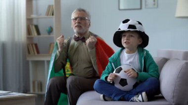 Portekiz bayrağı sallayarak torunu evde birlikte futbol izlerken ihtiyar