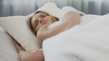 Güzel kız rahat yatak çarşafları, uyanmak için tembel, sınıfları için geç yatan