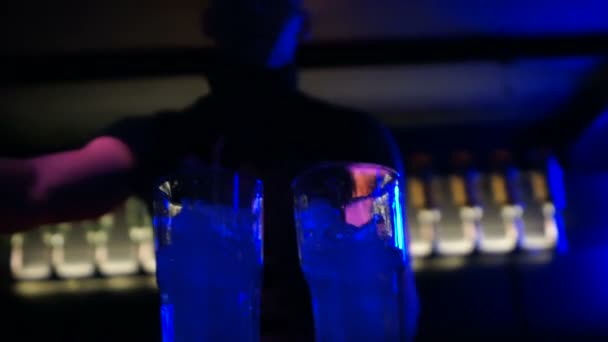 Barman vertiendo alcohol en vasos con cubitos de hielo, sacudiendo y haciendo trucos — Vídeos de Stock