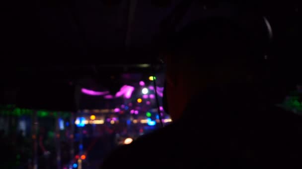 Disco jockey com fone de ouvido realizando no clube noturno, entretenimento, câmera lenta — Vídeo de Stock