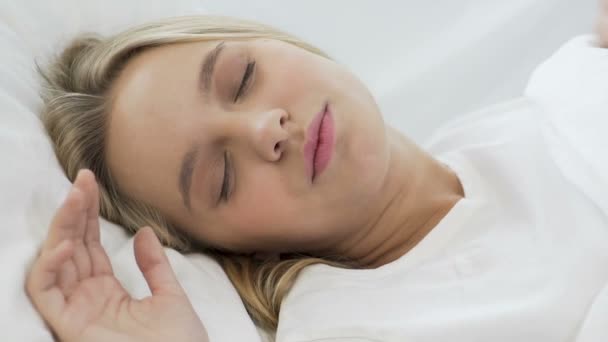Tienermeisje die zich uitstrekt in bed na gezonde slaap op zacht beddengoed, close-up — Stockvideo
