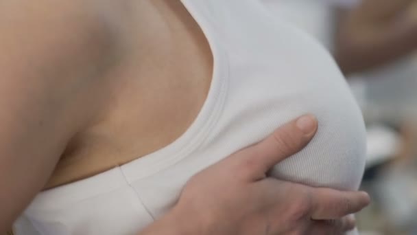 Donna guardando il seno dopo l'intervento chirurgico di aumento, torace cadente, primo piano — Video Stock