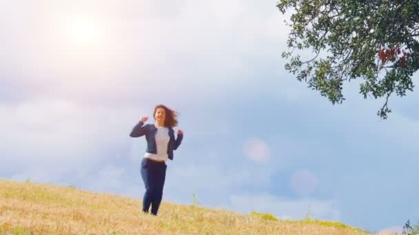 Glückliche junge Frau genießt wunderbares Leben, springt auf Feld, aufgeregter Mensch — Stockvideo