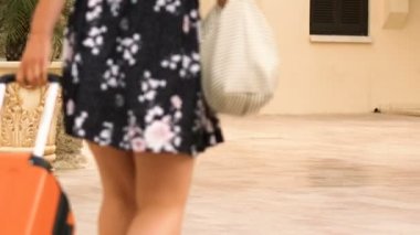 Çekici kadın haddeleme tekerlekli bavul, otel, yaz tatili bırakarak