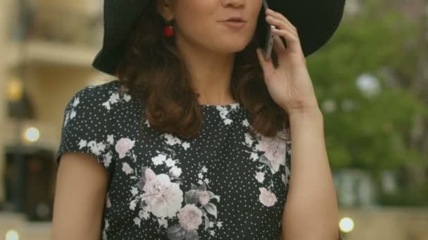 Όμορφη γυναίκα με καπέλο μιλάει στο κινητό τηλέφωνο γκρο πλαν, μικροεφαρμογής επικοινωνίας — Αρχείο Βίντεο