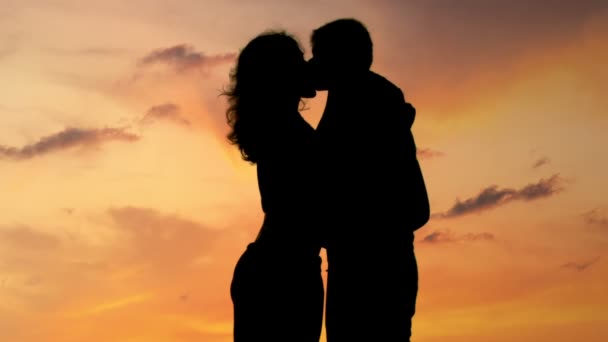 Hermosa pareja romántica disfrutando de increíble puesta de sol, besos y abrazos, primer plano — Vídeo de stock