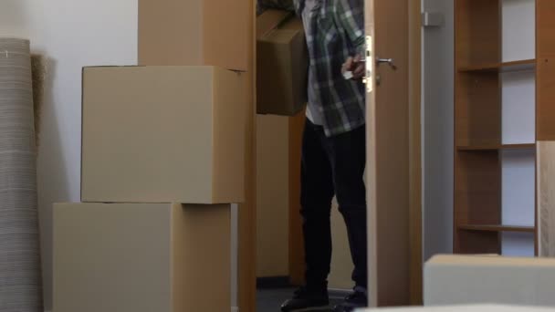 Homem segurando chave trazendo coisas para novo apartamento, satisfeito com compra plana — Vídeo de Stock