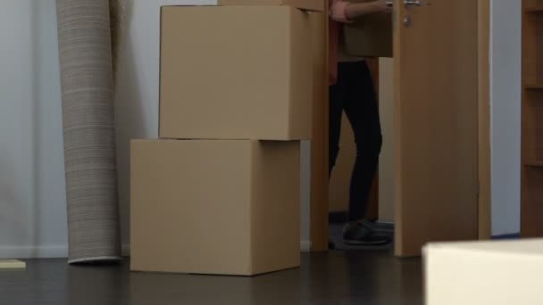 Studentin trägt Kisten in Mietwohnung, Beginn eines neuen Lebens — Stockvideo