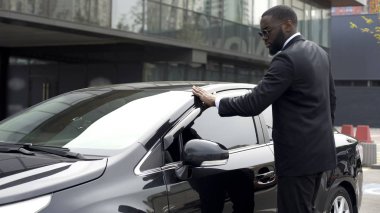 Vicdanlı Afro-Amerikan adam yeni arabasını otoparka terk etmeden önce silme