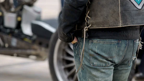 彼のクールなバイクの横に立っているジーンズのポケットに手でタフなバイク — ストック写真