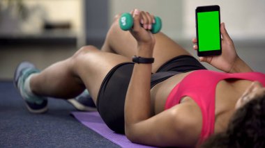 Kol dumbbell ile esneme telefonunuzun ve yeşil ekran ile karışık yarış genç erkek
