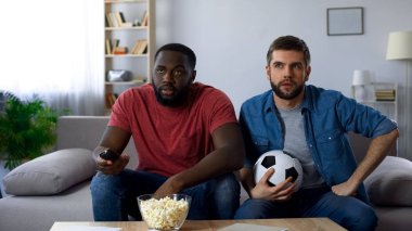 İki futbol taraftarları kurallarını anlamaya çalışan Amerikan futbolu maçı izlerken