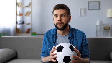 Heyecanlı adam endişeyle izlerken futbol maç TV evde, ilk yarının sonunda