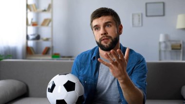 On tv ev, takım zararına sinirli sinirli izlerken futbol maçı genç adam