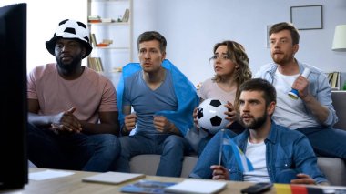 Evde, futbol oyun izlerken çok ırklı Arjantinli arkadaşlar beraberlik