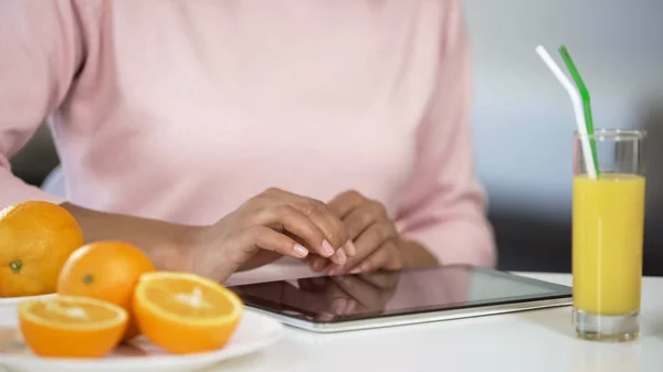 Nainen Käyttää Tabletin Pöydässä Appelsiinit Etsivät Ravitsevaa Ruokavaliota Vitamiini — kuvapankkivalokuva