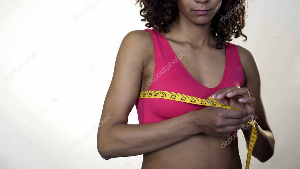 Sport lady measuring chest with yellow tape, breast augmentation, weight loss