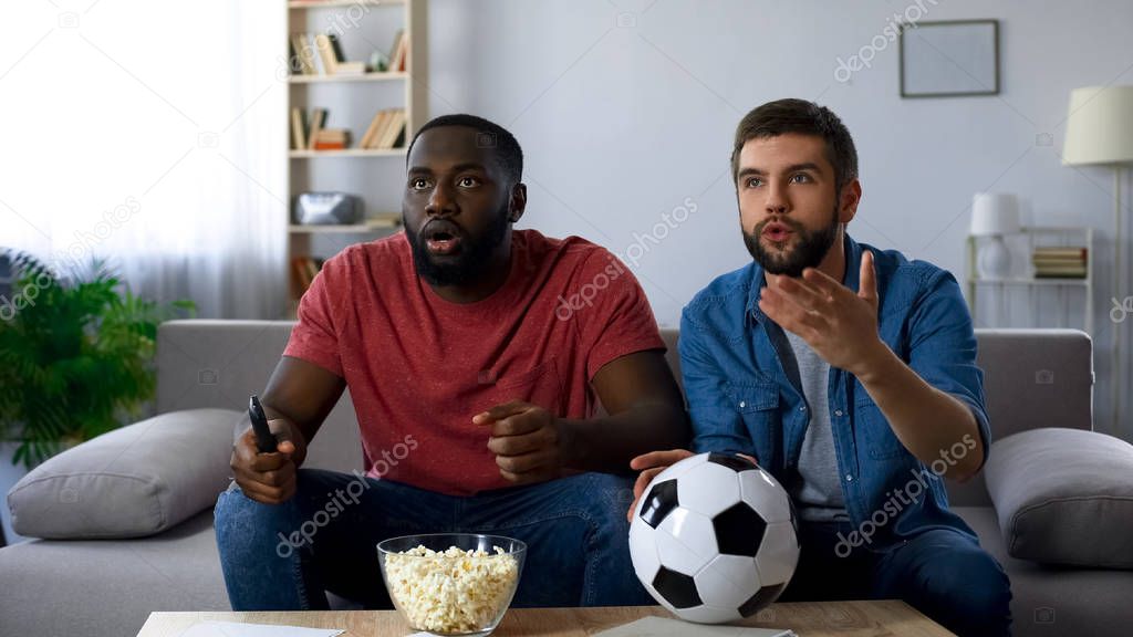 Multiethnic guys watching football match, frustrated by defeat of favourite team