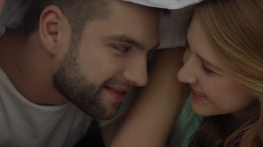 Mutlu çift yalan yatak, güvenli seks, samimi ilişkiler için prezervatif sunan el