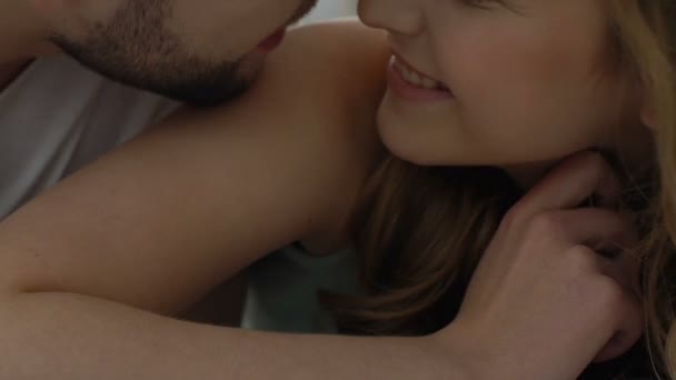 Casal nuzzling na cama, feminino mostrando preservativo para namorado, sexo seguro, close-up — Vídeo de Stock