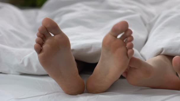 Γυναίκα αγγίζοντας πόδι ο άντρας στο κρεβάτι, φλερτάρουν και οικειότητα σχέσεις, γκρο πλαν — Αρχείο Βίντεο