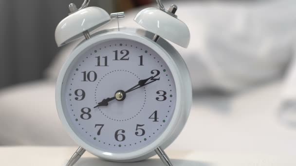 Magnifique réveil blanc sur la table près du lit, gestion du temps et délai 