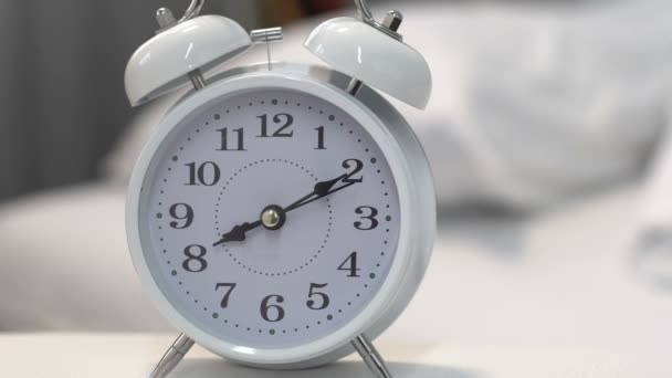 Hermoso reloj despertador blanco en la mesa cerca de la cama, gestión del tiempo y fecha límite — Vídeos de Stock