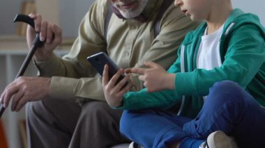 Büyükbaba nasıl smartphone uygulama, iletişim kullanılacağını gösteren erkek çocuk