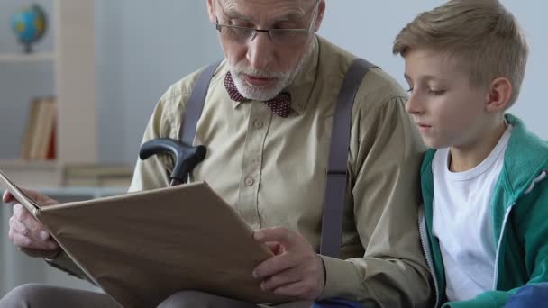 Αγαπώντας παππούς ανάγνωση του βιβλίου για το μικρό αγόρι, ανταλλαγή γνώσεων, ευτυχισμένη παιδική ηλικία — Αρχείο Βίντεο