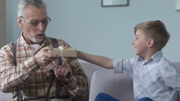 Милый мальчик представляет подарочную коробку дедушка, счастливые семейные моменты, любовные отношения — стоковое видео