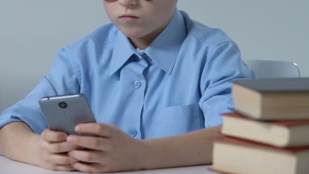 かわいい学校の生徒机、ガジェット中毒でインターネットをサーフィン ゲーム — ストック動画