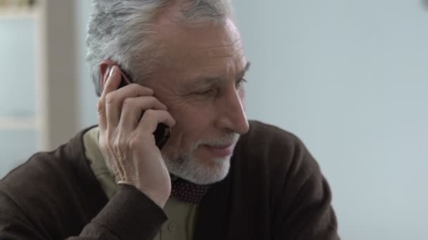 Старший джентльмен разговаривает по телефону с детьми, семейное общение, гаджет — стоковое видео