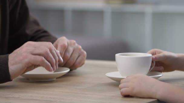Дедушка и ребенок разговаривают и пьют чай, проводят время вместе, общаются — стоковое видео
