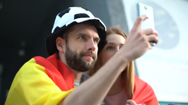 Aficionados al fútbol español haciendo selfie divertido en asientos del estadio, campeonato de fútbol — Vídeo de stock