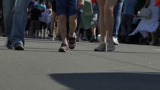 Muchas personas piernas caminando a lo largo de amplia calle urbana, festival de la ciudad, cámara lenta — Vídeo de stock