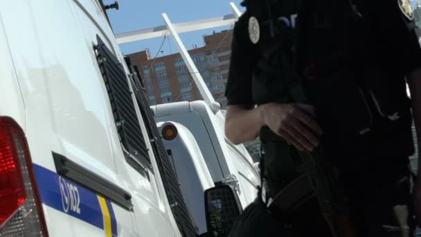 Уверенные в себе полицейские медленно идут по парковке патрулируя улицы города — стоковое видео