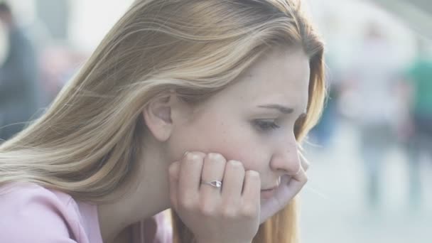 Wind speelt met haar droevige meisje eenzaam zitplaatsen op straat, uiteenvallen depressie — Stockvideo